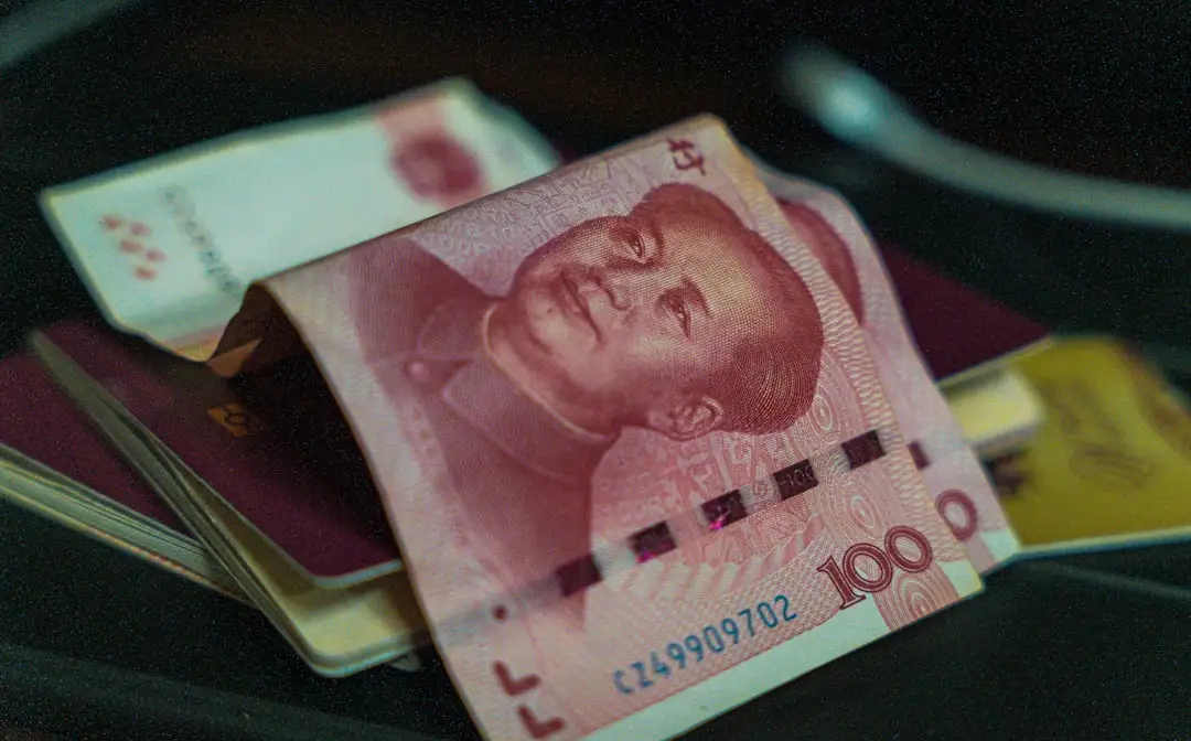 Chinese visa stamp resting on a passport next to travel documents